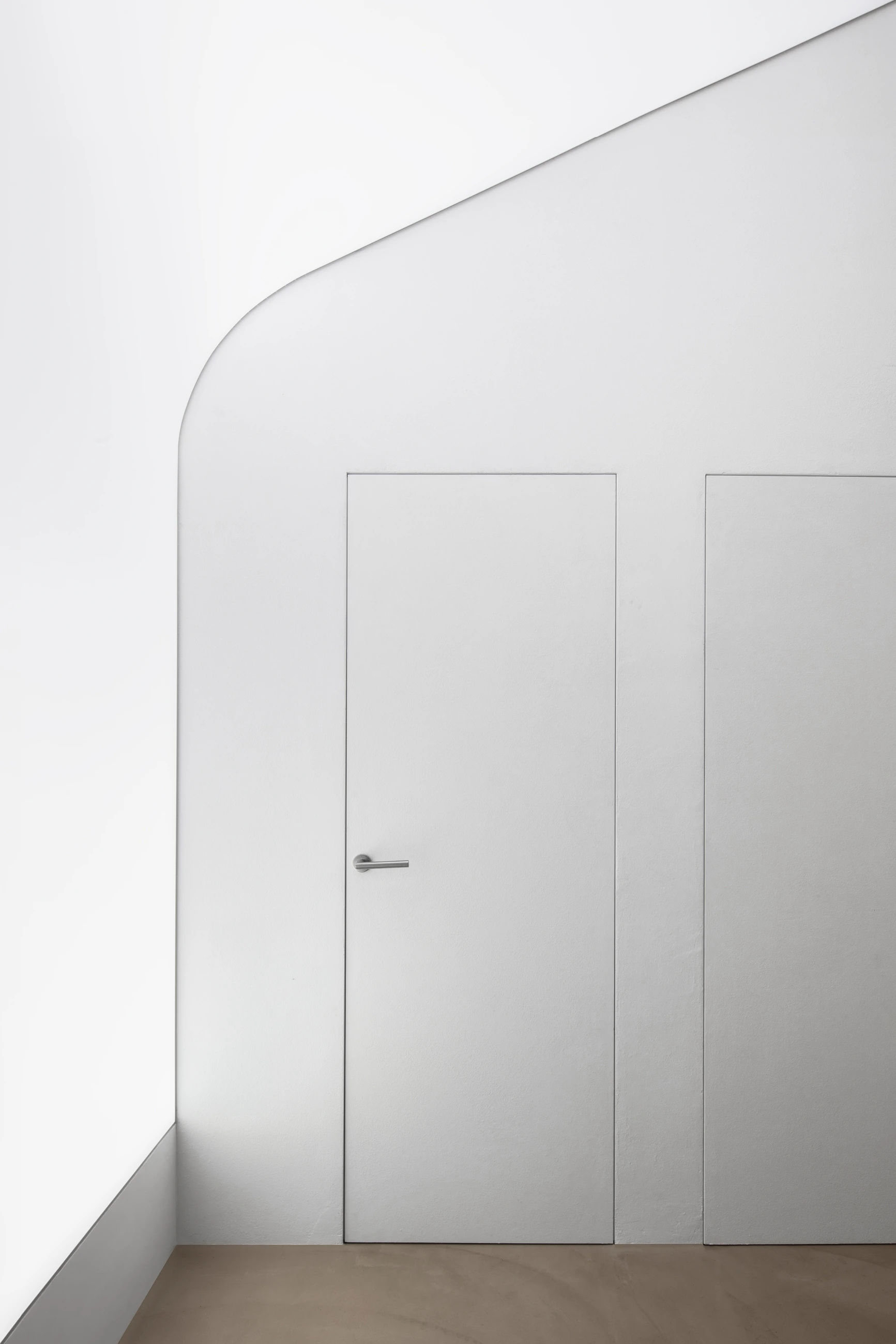 Loft GC, parete curva bianca e porte a filo