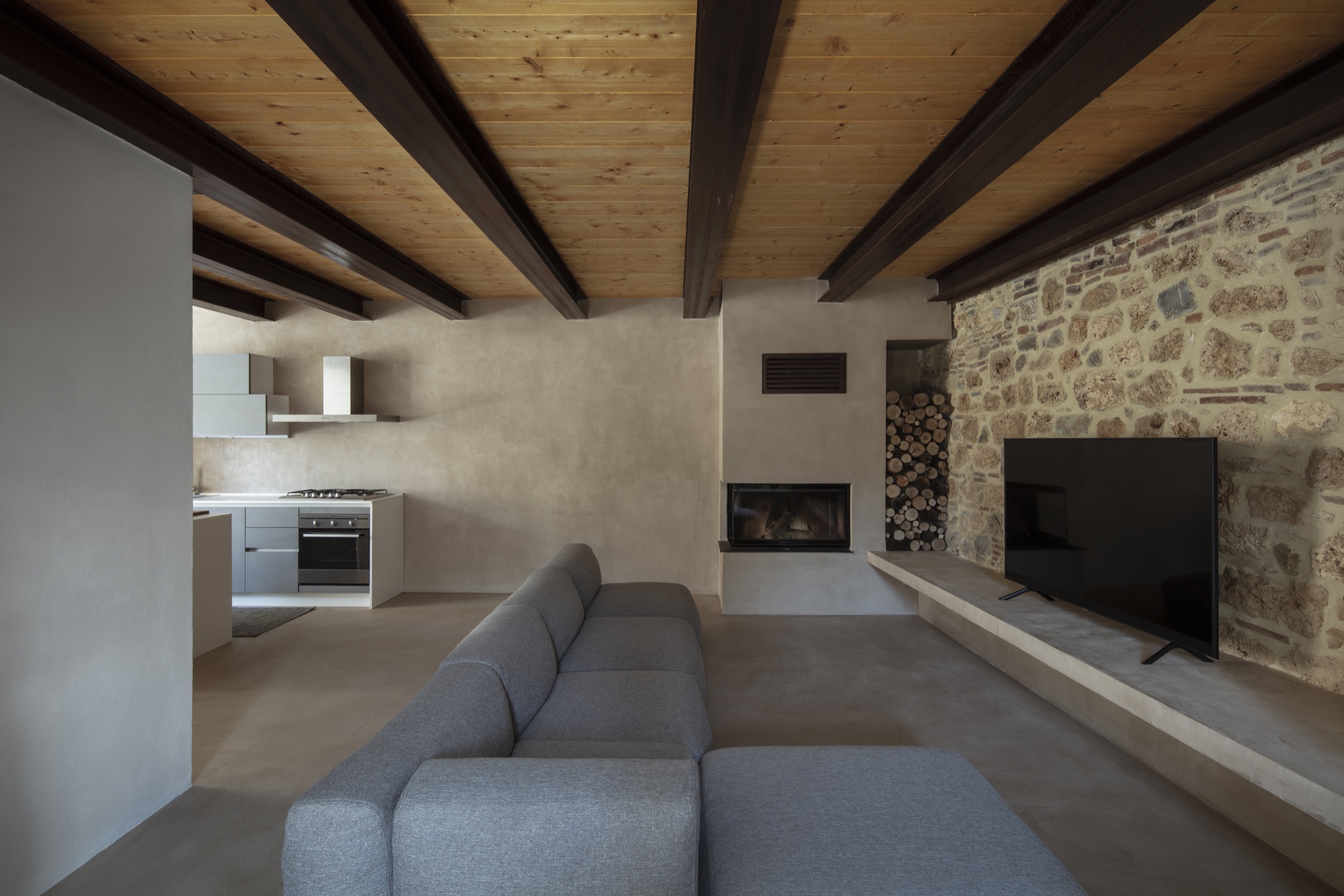 Loft GC, interno contemporaneo tra pietra, legno e superfici continue